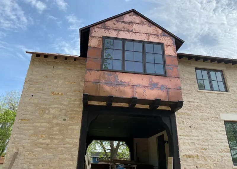 Copper metal panel facade on a stone building for Roof Repair in Pearsall